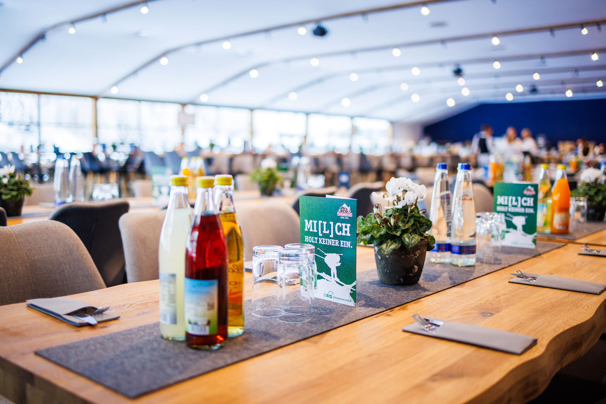 vip_hospitality_gt2a8833 Nahaufnahme eines gedeckten VIP-Tisches mit Getränkeflaschen, Gläsern und Werbekarte.