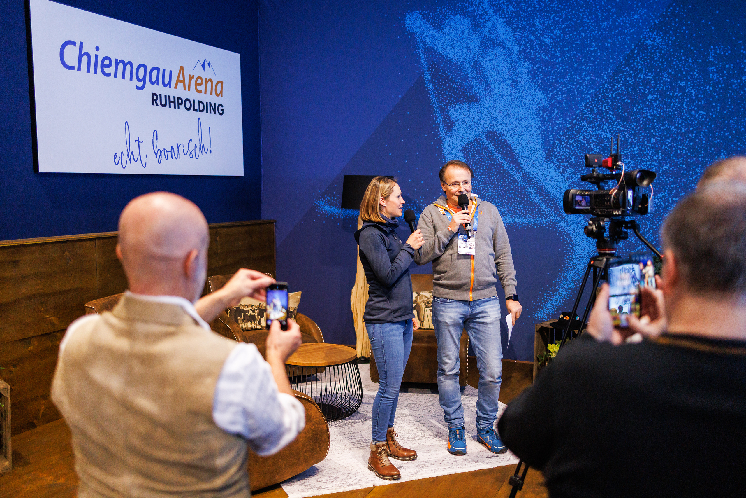 VIP_GT2A5180 Moderation auf kleiner VIP-Bühne in der Chiemgau Arena, Gäste filmen das Gespräch mit dem Smartphone.
