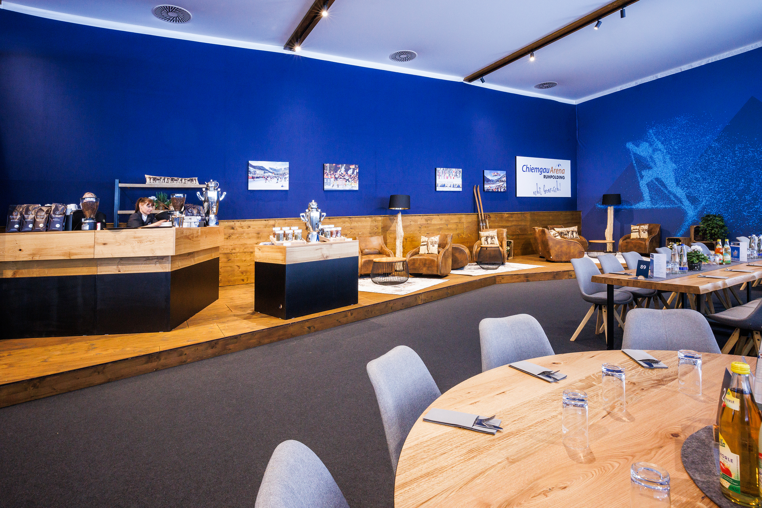 VIP_GT2A8769 VIP-Lounge mit blauer Wand, Buffettheke, Pokalen und gemütlichen Sitzbereichen im Hospitality-Bereich der Chiemgau Arena.