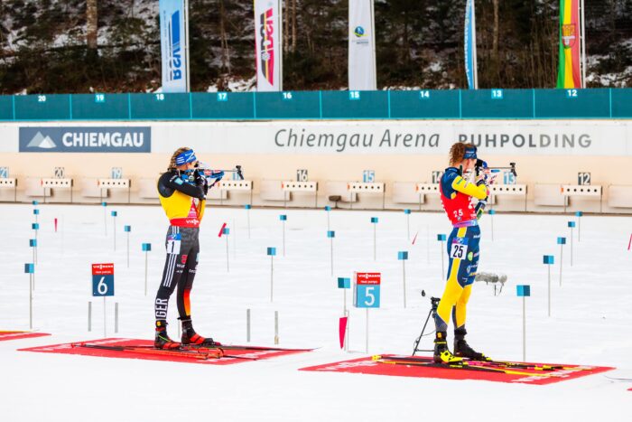 Verfolgung_Frauen_GT2A1708 Zwei Biathletinnen stehen nebeneinander am Schießstand und absolvieren ihre Schießeinlage.